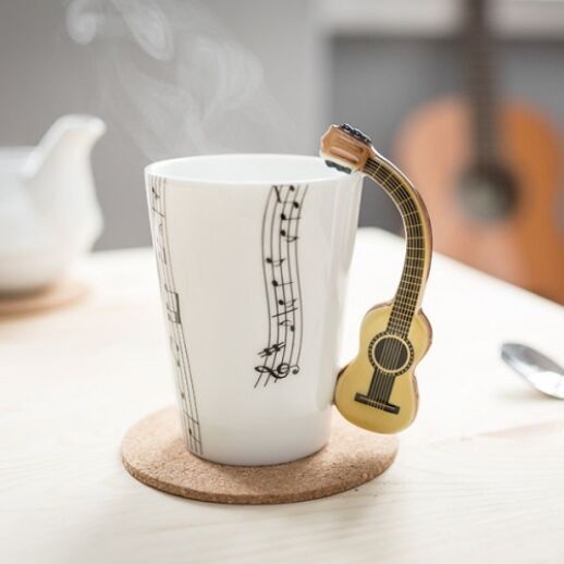 Tasse mit verschiedenen Musikinstrumenten bzw. Notenschlüssel als Henkel